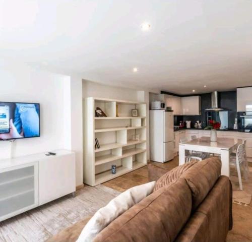 un salon avec un canapé et une cuisine dans l'établissement Maison de luxe confortable, à Douvaine