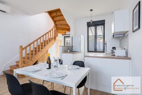 une salle à manger blanche avec une table et des chaises blanches dans l'établissement Agréable Maisonnette à Proximité d'Eurexpo, à Saint-Priest