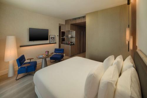 a hotel room with a large bed and a tv at NH Collection Milano CityLife in Milan
