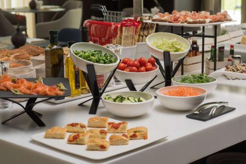 a buffet with different types of food on a table at NH Collection Milano CityLife in Milan