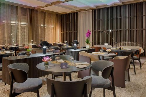 a restaurant with tables and chairs in a room at NH Collection Milano CityLife in Milan