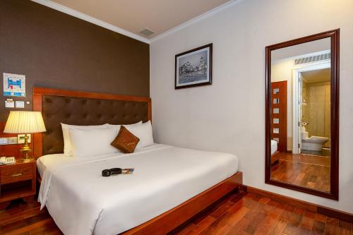 a bedroom with a large bed and a mirror at Samdi Grand Danang in Da Nang