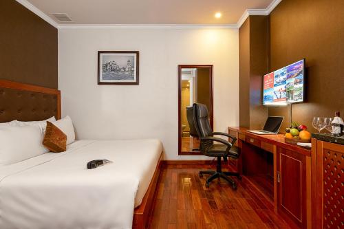 a hotel room with a bed and a desk with a computer at Samdi Grand Danang in Da Nang