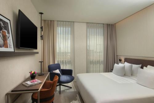 a hotel room with a large bed and a desk at NH Collection Milano CityLife in Milan
