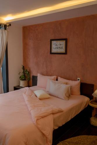 a large bed with white pillows in a bedroom at Du De Homestay in Hoi An