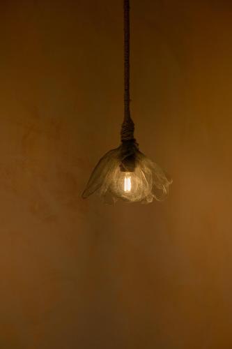 a glass light fixture hanging from a ceiling at Du De Homestay in Hoi An