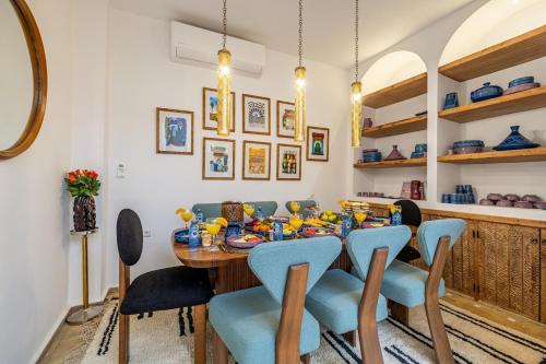 a dining room with a table and blue chairs at Riad Dar Catalia-Exclusive&HeatedPool-FreeBreakfas in Marrakech