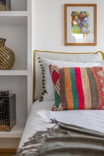a bedroom with a bed with a colorful pillow on it at Riad Dar Catalia-Exclusive&HeatedPool-FreeBreakfas in Marrakech