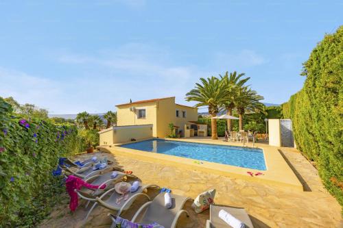 a swimming pool with lounge chairs and a house at Villa Carola - PlusHolidays in Ifach