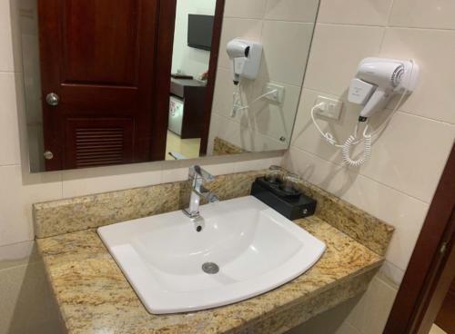 a white sink in a bathroom with a phone at Kenny Hotel Ha Long in Ha Long