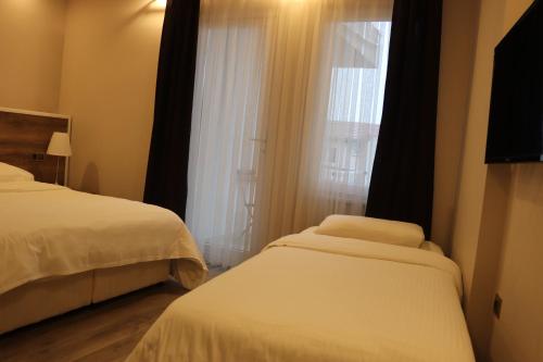 a hotel room with two beds and a window at Yankı Hotel in Çekirge