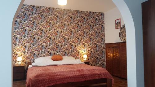 a bedroom with a bed with a colorful wall at Willa Rodzinna in Tylicz