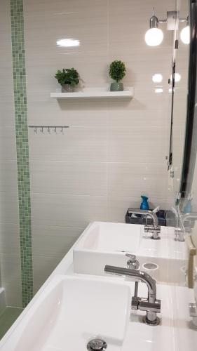 a white bathroom with two sinks and a mirror at Willa Rodzinna in Tylicz