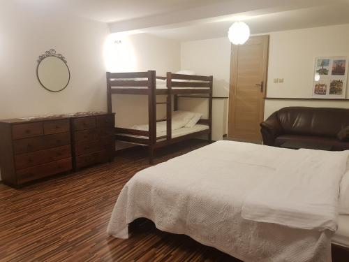 a bedroom with a bed and two bunk beds at Willa Rodzinna in Tylicz
