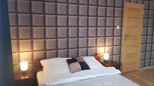 a bedroom with a large padded wall behind a bed at Willa Rodzinna in Tylicz