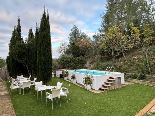 a backyard with a pool and tables and chairs at Paraiso Natural Unico -Villa Cueva Turche in Valencia