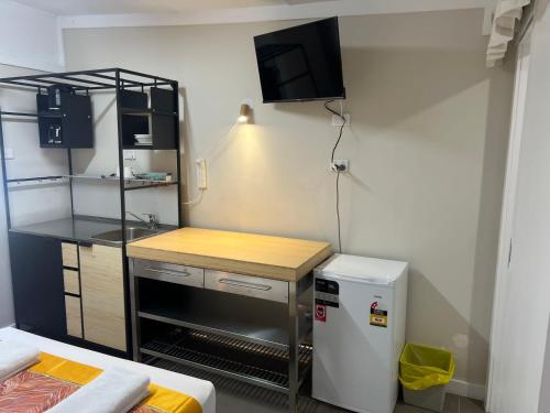 a small kitchen with a counter and a refrigerator at Kalua Motel in Bundaberg
