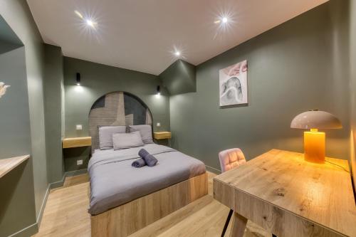 une chambre avec un lit et une table en bois dans l'établissement Appartement moderne proche Paris, à Bagnolet