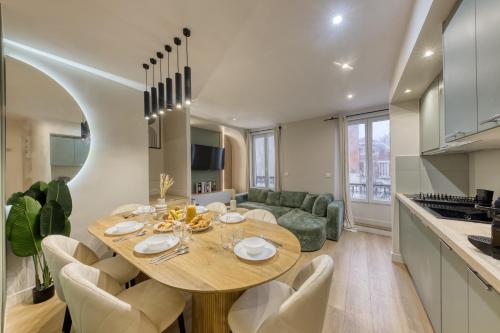 une cuisine et une salle à manger avec une table et des chaises dans l'établissement Appartement moderne proche Paris, à Bagnolet