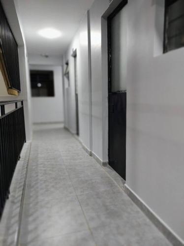 a hallway with black doors and a tile floor at One bedroom apartment Aviv in Nairobi
