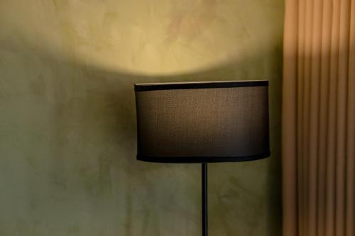 a black lamp in a corner of a room at Du De Homestay in Hoi An