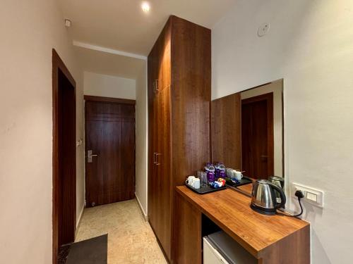 a kitchen with a counter and a wooden cabinet at Vyom Boutique Hotel Rishikesh in Rishīkesh