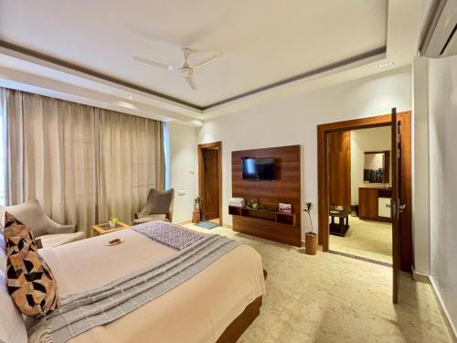 a hotel room with a bed and a television at Vyom Boutique Hotel Rishikesh in Rishīkesh
