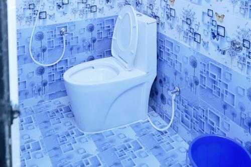 a bathroom with a toilet in a blue tiled wall at Hotel SONIA MAHI INN KANYAKUMARI in Kanyakumari