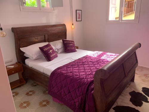 a bedroom with a bed with purple blankets and pillows at Old Town Retreat in Rhodes Town