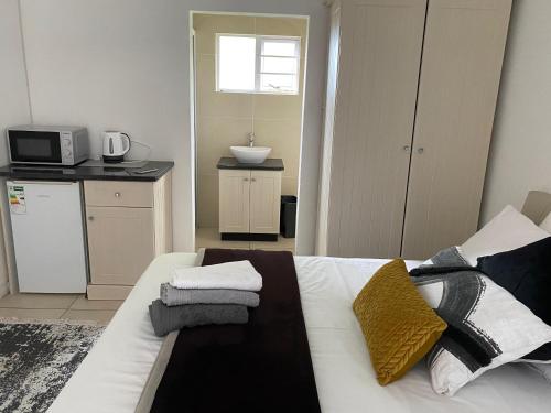 a bedroom with a white bed with towels on it at Travellers Rest in Grahamstown