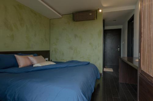 a bedroom with a bed with blue sheets and pink pillows at Du De Homestay in Hoi An