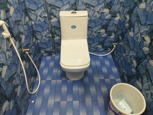 a toilet in a bathroom with a rock wall at Hotel SONIA MAHI INN KANYAKUMARI in Kanyakumari
