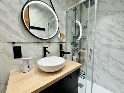 une salle de bain avec un lavabo et un miroir dans l'établissement Havre de Paix - Quartier Drouot Opéra, à Paris