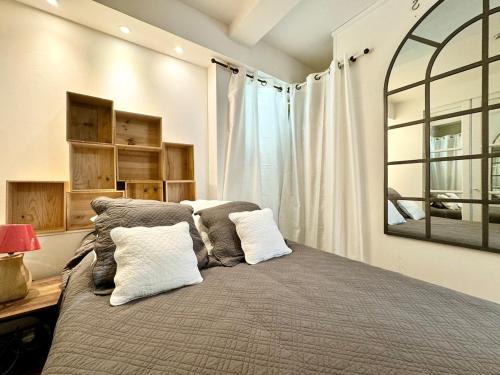 une chambre avec un grand lit avec deux oreillers dans l'établissement Havre de Paix - Quartier Drouot Opéra, à Paris