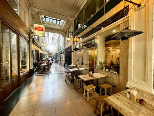 un restaurant avec des tables et des chaises dans un bâtiment dans l'établissement Havre de Paix - Quartier Drouot Opéra, à Paris