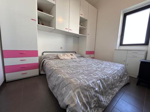 a bedroom with a bed and cabinets and a window at La Casetta in Montagna by Holiday World in Lucoli Alto
