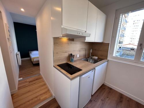 une petite cuisine avec des armoires blanches et un évier dans l'établissement Compans - Calme, à Toulouse
