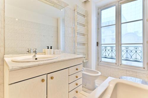 une salle de bain avec un lavabo, une baignoire et des toilettes dans l'établissement Charming very spacious apartment, Paris 9ème, à Paris
