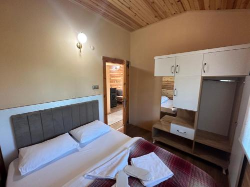 a bedroom with a large bed and a mirror at SultanMurat-Otel-Görnek Tabiat Parkı in Trabzon