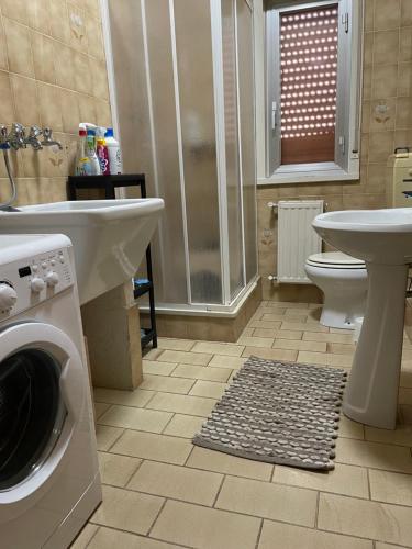 a bathroom with a washing machine and a toilet and a sink at Appartamento Vittoria in Grotte