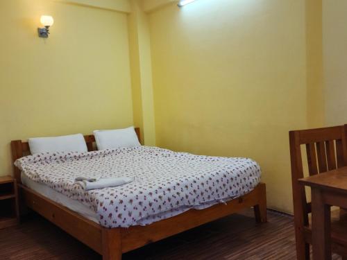 Dormitorio pequeño con cama con edredón blanco en Hotel Silver Mountain, en Nagarkot