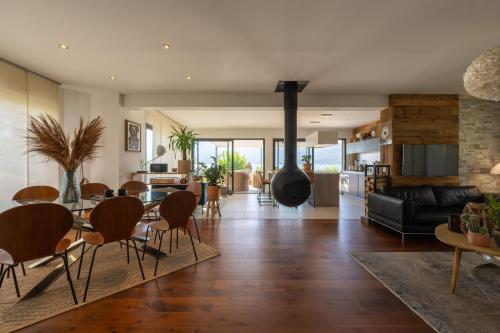 Il comprend un salon et une salle à manger avec une cheminée. dans l'établissement Villa Belle Rive - Villa les pieds dans l'eau, à Veyrier-du-Lac