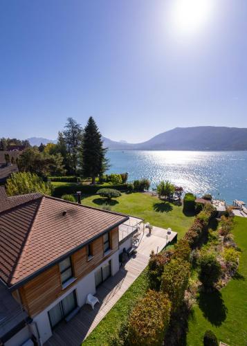 - une vue aérienne sur une maison et l'eau dans l'établissement Villa Belle Rive - Villa les pieds dans l'eau, à Veyrier-du-Lac