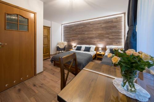 a bedroom with a bed and a table with a vase of flowers at Agroturystyka Folwarczek Pokoje i Apartamenty in Ustroń