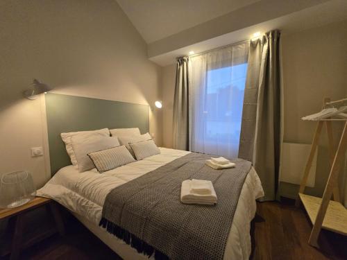 a bedroom with a bed with two towels on it at Natural Design Lodge Villa Nomade groupe avec jacuzzi centre de Milly la Forêt ! in Milly-la-Forêt