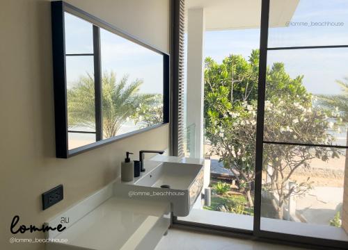 a bathroom with a sink and a large window at lomme Private Beach House in Cha Am