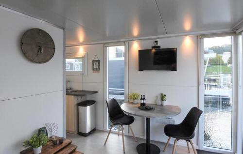 sala de estar con mesa, sillas y reloj en House Boat Maastricht, en Maastricht