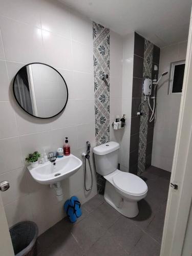 a bathroom with a toilet and a sink and a mirror at AzzSpacesAnderson in Ipoh