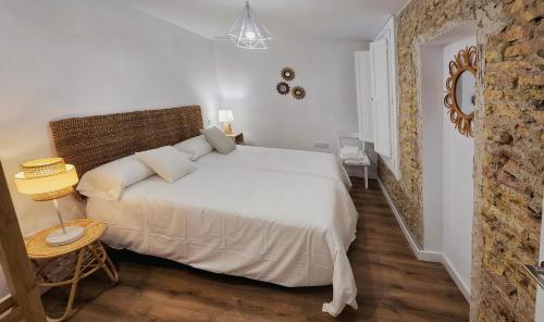 a white bedroom with a bed and a table at Apartamentos Almada - calle Alfonso - Plaza SAS in Zaragoza