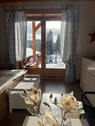 a room with two beds and a window with a view at Apartament Borowikowe Zacisze in Falsztyn